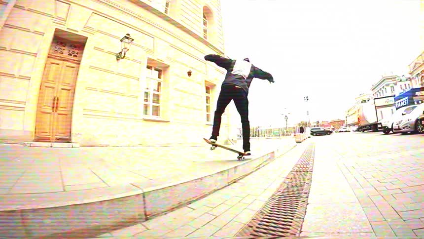Slow-motion fisheye shot of a skateboarder executing a manual trick on a curved city sidewalk ledge with a vintage filter