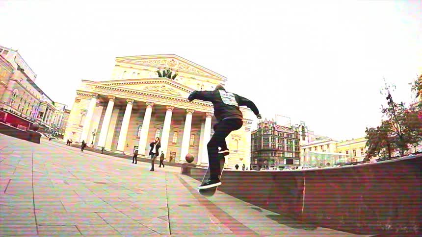 Slow-motion fisheye shot of a skateboarder performing tricks in a historic city square in front of a grand theater