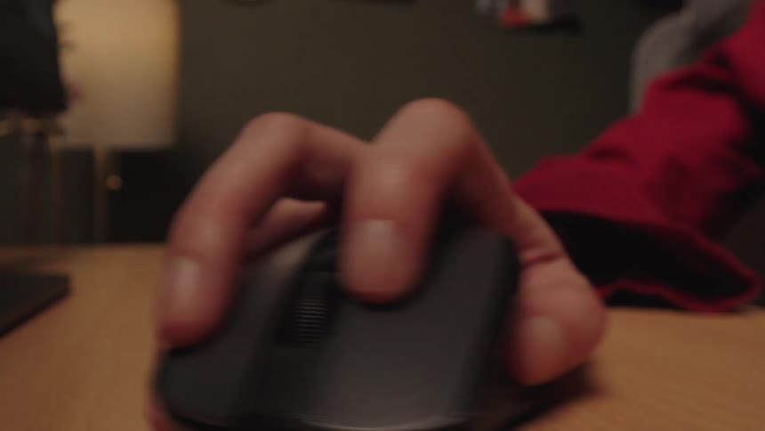 Extreme close-up on a hand repeatedly and rapidly clicking a computer mouse