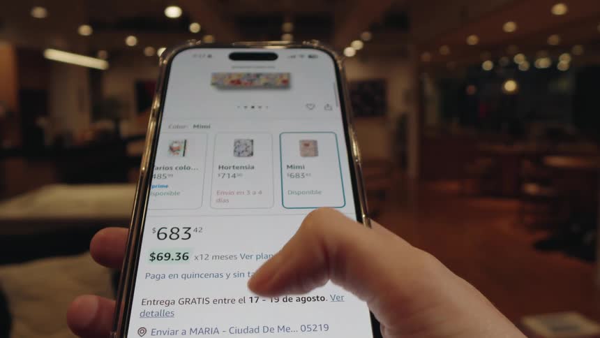 A person shops for a floral notebook on an e-commerce website using their smartphone, scrolling through the options and finally clicking the buy now button