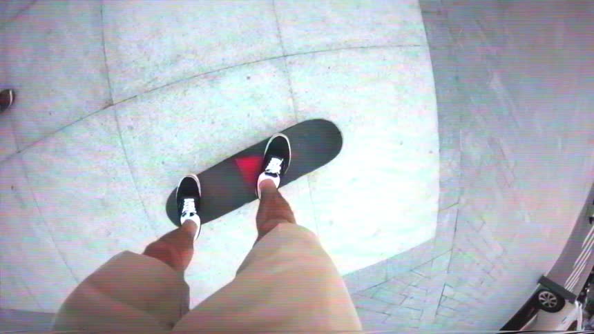First-person point-of-view of a person standing on a skateboard with a lo-fi VHS effect