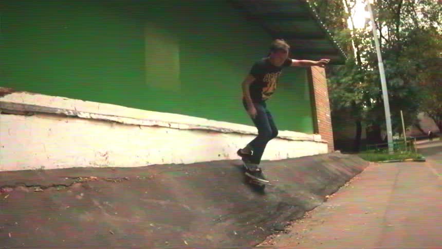 Skateboarder performs a stylish grab trick on an urban ramp in this retro, slow-motion clip