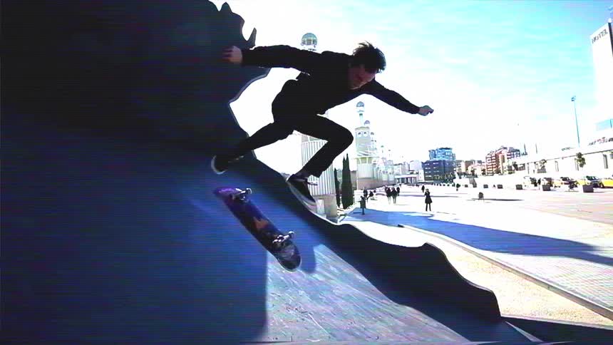A skateboarder performs a kickflip trick in slow motion off a ramp in a sunny, urban plaza