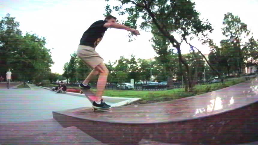 Slow motion retro footage shows a skateboarder bailing a trick on a smooth marble ledge and sliding to a dramatic fall in an urban park