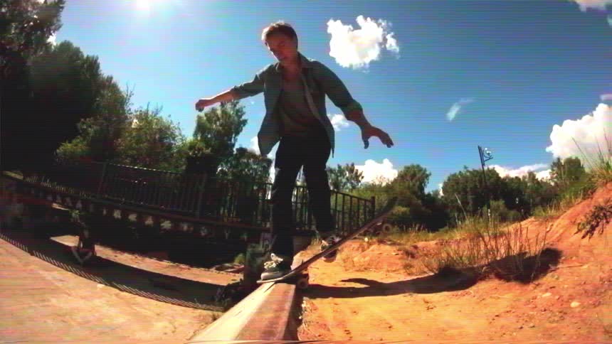 A skateboarder in slow motion performs a kickflip off a ledge into a concrete ditch in this vintage-style, fisheye shot