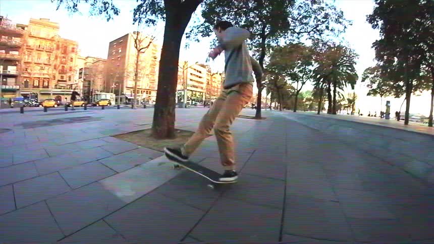 A skateboarder performs impressive tricks on a city street in super slow motion, captured with a fisheye lens