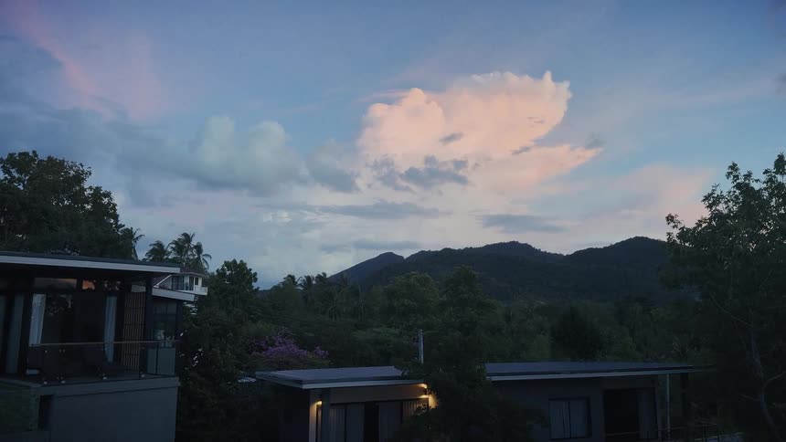 Serene view of a tropical mountain landscape with houses nestled in the lush green jungle at twilight