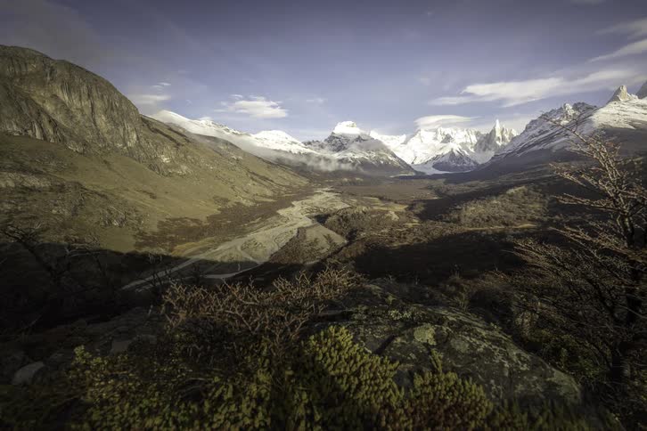 A stunning timelapse reveals moving clouds and shifting shadows across the majestic Fitz Roy mountain range and a river valley in Patagonia