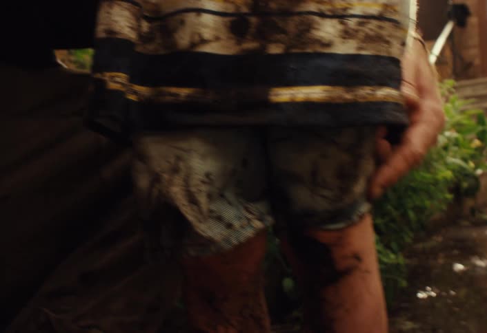 A close-up shot shows a father and son standing together, completely covered in mud from playing outside