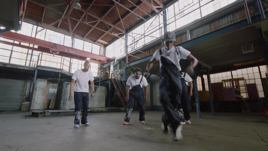 A talented hip-hop dancer showcases his energetic moves in an industrial warehouse as his crew watches