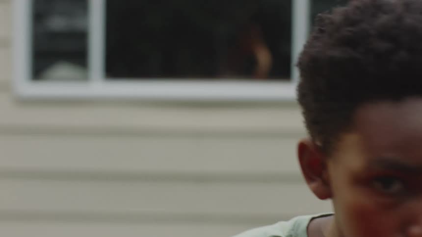 Close-up slow-motion POV of a determined young boy practicing boxing and punching towards the camera