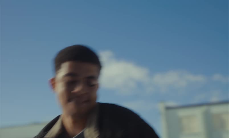 A young man is aggressively grabbed and shaken during an intense physical confrontation outdoors