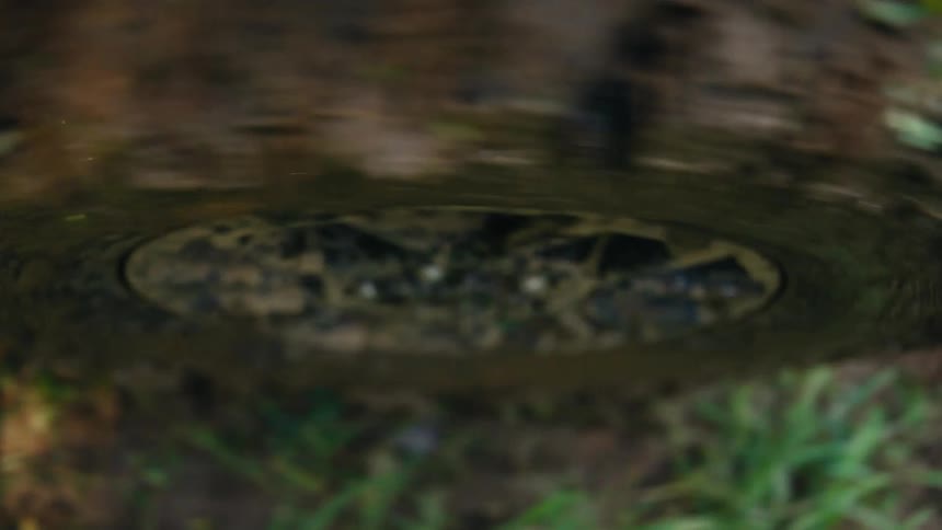 Abstract slow-motion close-up of a muddy off-road tire spinning through dirt and debris