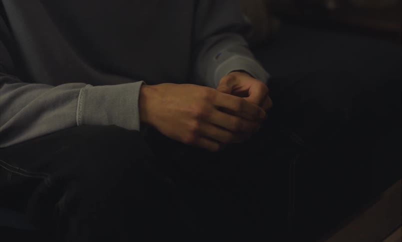 A close-up shot of a person's hands fidgeting nervously, suggesting anxiety or contemplation
