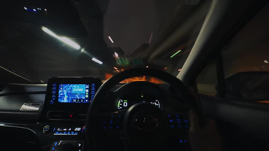 A fast-paced point-of-view hyperlapse shows a surreal night drive through a brightly lit city with stunning light trails