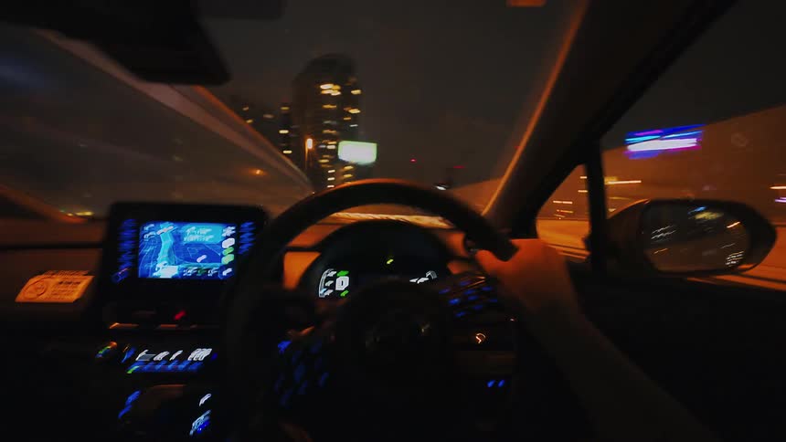 A thrilling driver's point-of-view time-lapse captures the experience of speeding through a city highway at night, surrounded by blurred streaks of urban lights