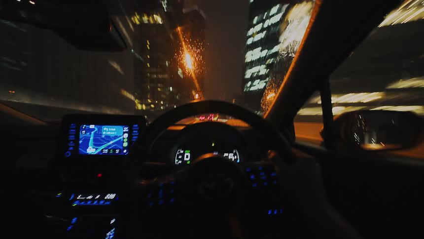 First-person point-of-view hyper-lapse of driving through a modern city at night with blurred lights from high speeds