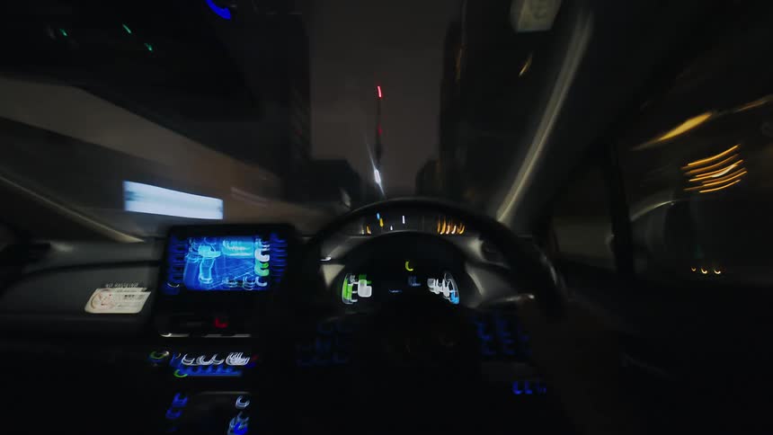 A first-person hyper-lapse perspective from the driver's seat of a car speeding through the illuminated city streets at night
