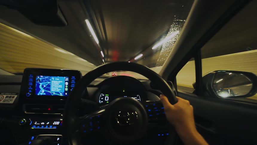 A dynamic point-of-view hyperlapse shows a car speeding through a brightly lit urban tunnel at night