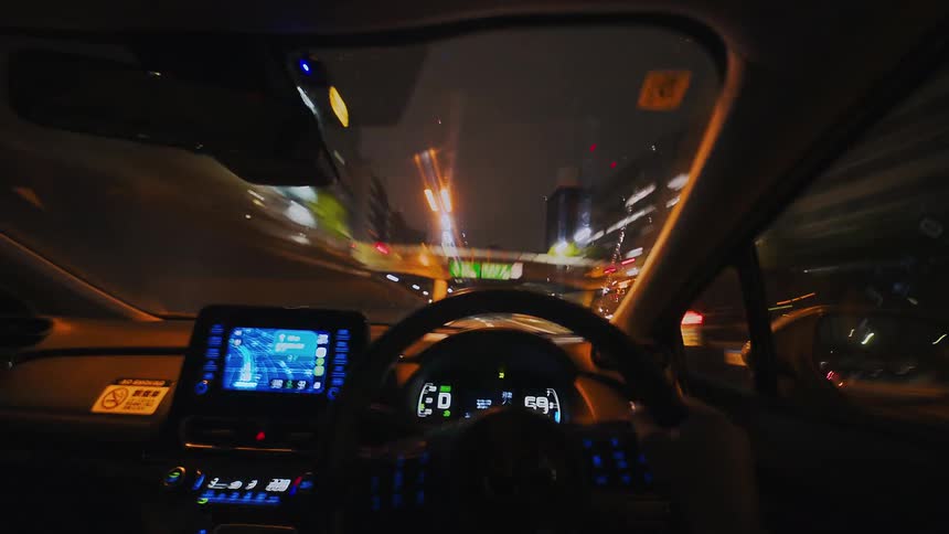 A surreal hyperlapse from the driver's point-of-view speeds through the city streets at night, with lights streaking past