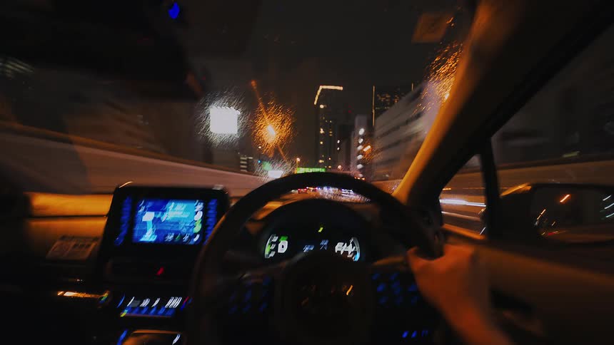 Hyper-lapse from the driver's point of view of a car speeding down a city highway at night, with lights blurring into streaks