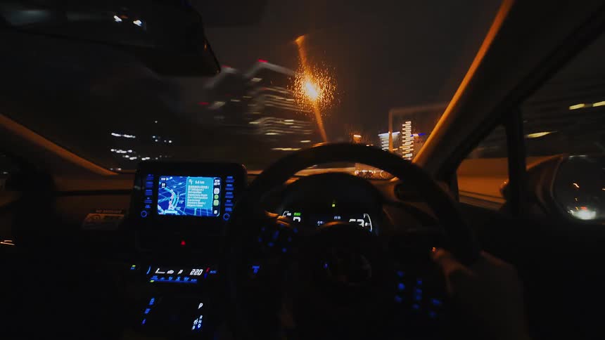 A mesmerizing first-person point-of-view time-lapse of driving through a modern city at night, with lights streaking past