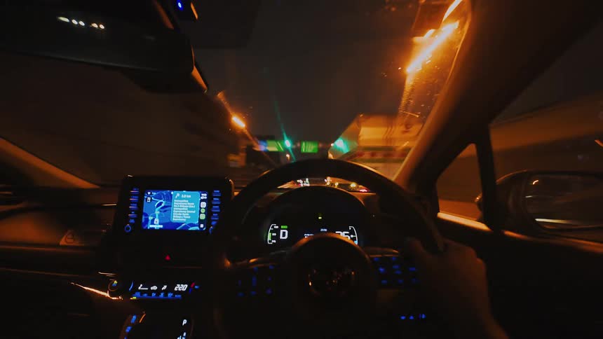 POV time-lapse of driving a car through a city highway at night, with light trails blurring past