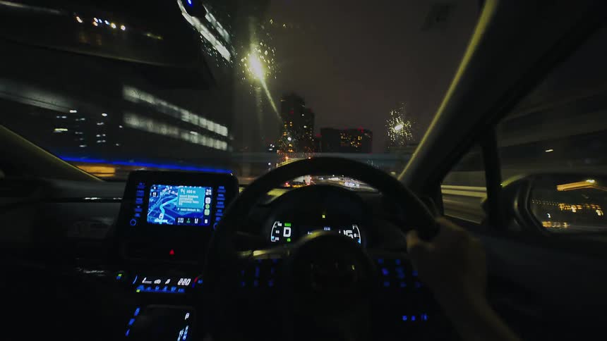 A fast-paced POV time-lapse captures the blur of city lights while driving on an urban highway at night