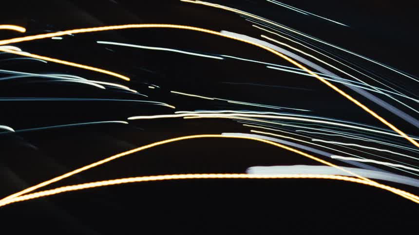 A dynamic and abstract montage of colorful, fast-moving light streaks captured with long exposure