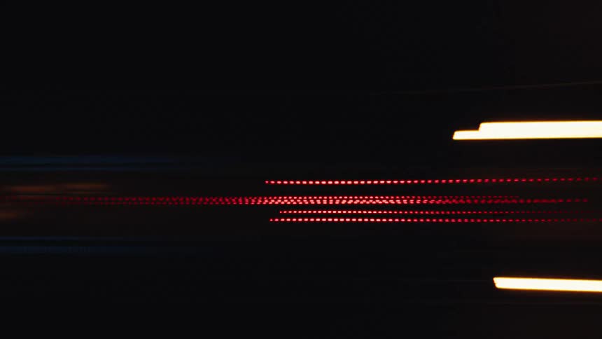 Abstract motion blur of red and yellow traffic lights creating dynamic streaks at high speed at night