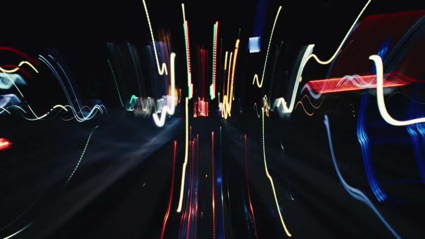 A surreal journey through colorful, abstract light trails that move like sound waves against a black void
