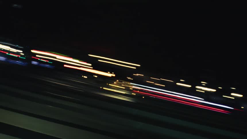 A mesmerizing abstract time-lapse of colorful light trails from fast-moving traffic on a freeway at night