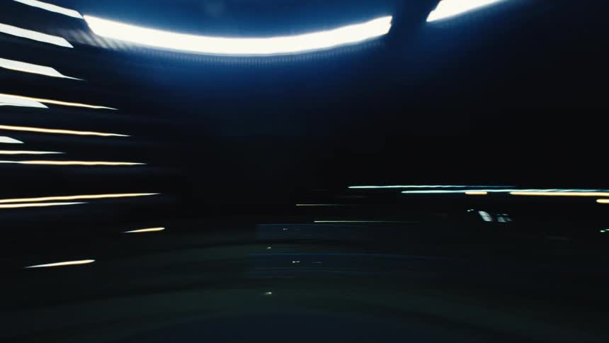 A fast-paced, abstract time-lapse of driving through a city at night, with colorful light trails streaking across the screen