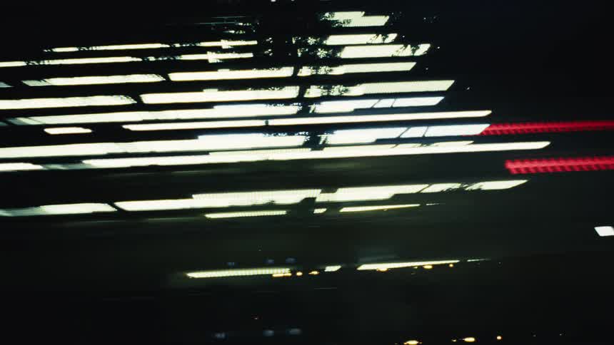A blur of vibrant city lights streaks past in a mesmerizing abstract motion at night