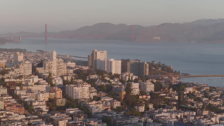 A golden hour timelapse shows the city of San Francisco with the iconic Golden Gate Bridge visible in the hazy background