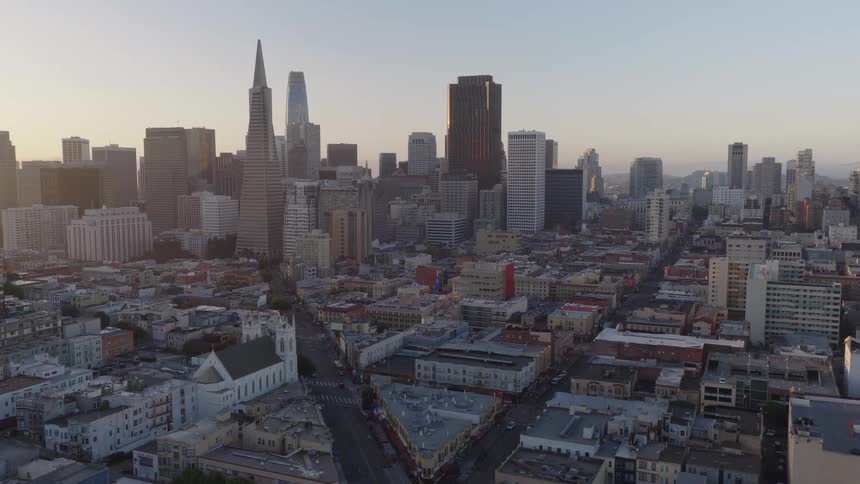An aerial view pulls back slowly from the downtown San Francisco skyline at golden hour