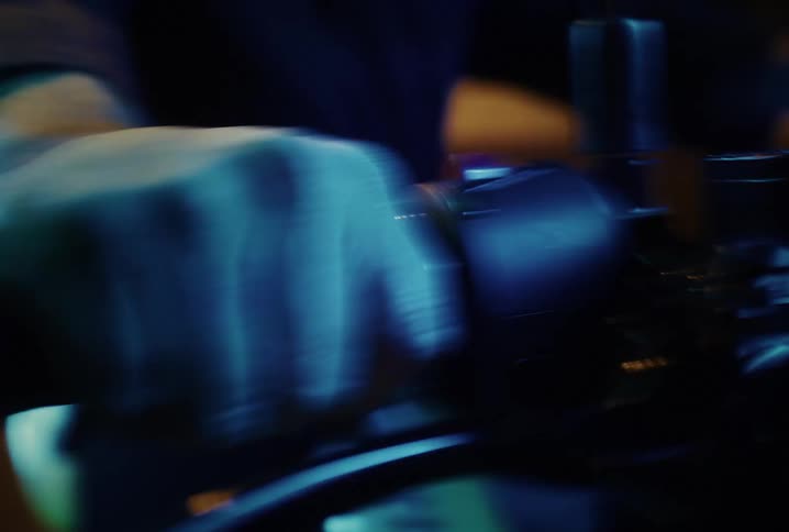 A shaky, stylized close-up of a hand gripping a motorcycle throttle during a chaotic night ride