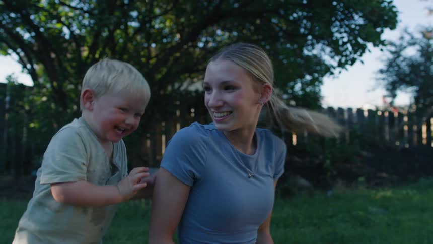 A loving mother and her adorable toddler son share a playful and joyful moment in their backyard