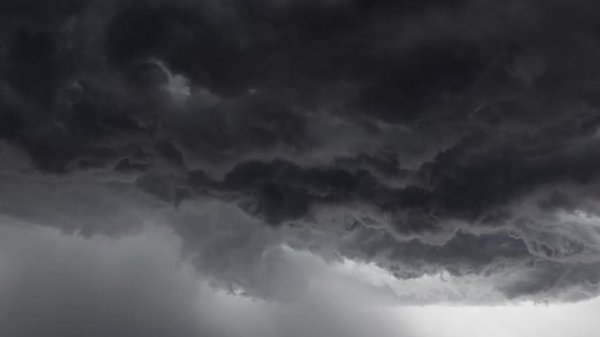 Dramatic lightning flashes within the dark, swirling clouds of an approaching thunderstorm