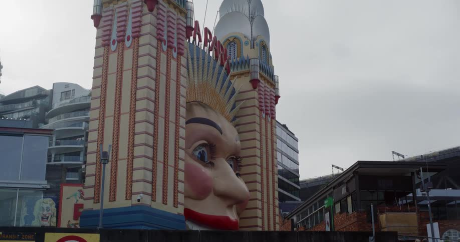 A slow pan reveals the iconic and slightly creepy smiling face at the entrance to Luna Park in Sydney on an overcast day