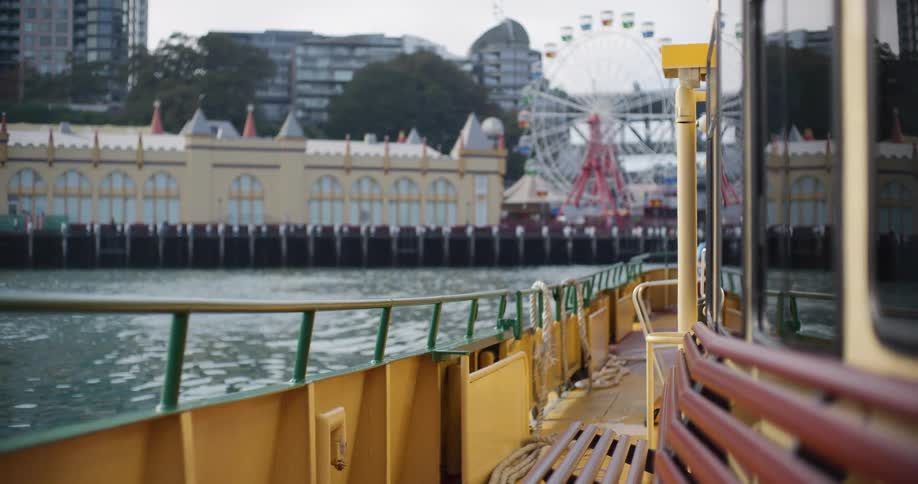 A scenic view from the deck of a ferry boat shows the out-of-focus Luna Park amusement park in Sydney, Australia