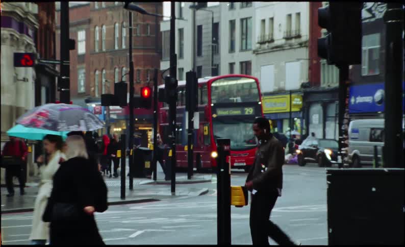 Handheld vintage film captures the bustling atmosphere of a London intersection with pedestrians and a double-decker bus on a rainy day
