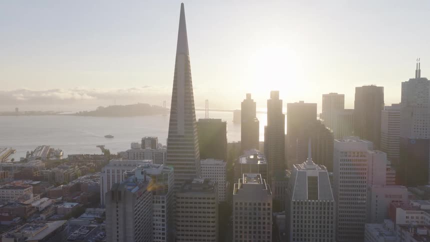 A cinematic aerial shot slowly rises over the San Francisco skyline as the sun rises over the bay, featuring the Transamerica Pyramid