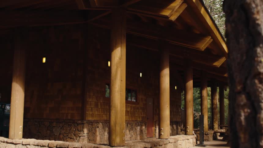A slow push in on a beautiful rustic wooden lodge in a serene forest setting