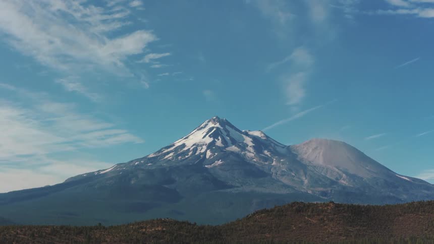 A majestic downward tilt reveals the snow-capped peak of Mount Shasta on a clear day