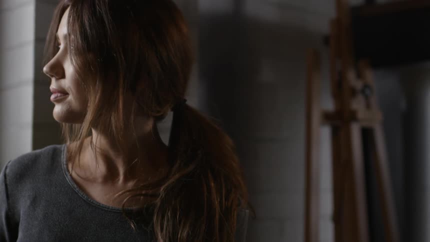 A woman looks to her side while indoors