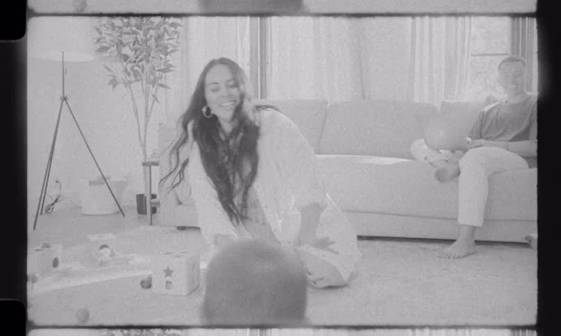 Vintage 8mm film of a cute baby crawling on the floor as loving parents watch in their cozy living room