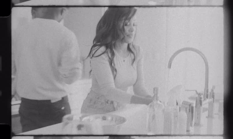 Vintage black and white home movie footage of a happy family spending time together in the kitchen