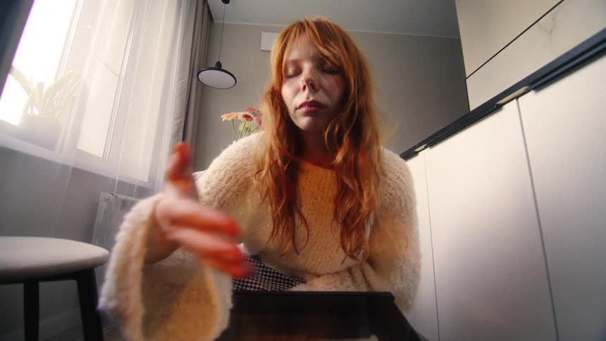 View from inside an oven as a red-haired woman performs a strange, slow-motion ritual before quickly closing the door