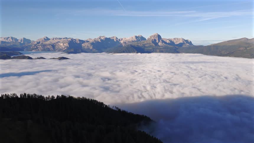 Stunning panoramic view of a mountain range rising above a vast sea of clouds at sunrise